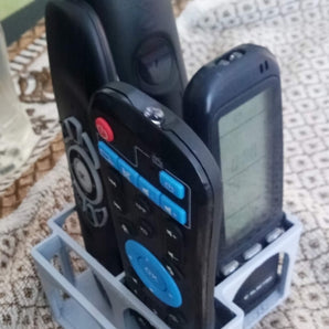 Fjernbetjeningsholder med indbygget smartphone-stativ